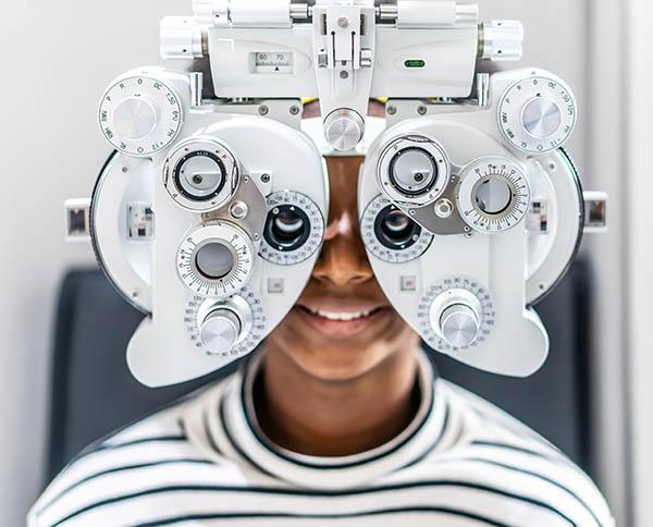 Smiling,Young,Woman,African,American,Afro,Hair,Doing,Eye,Test Person having a drivers license eye test at Vision Works Bayside. www.visionworksBayside.co.za